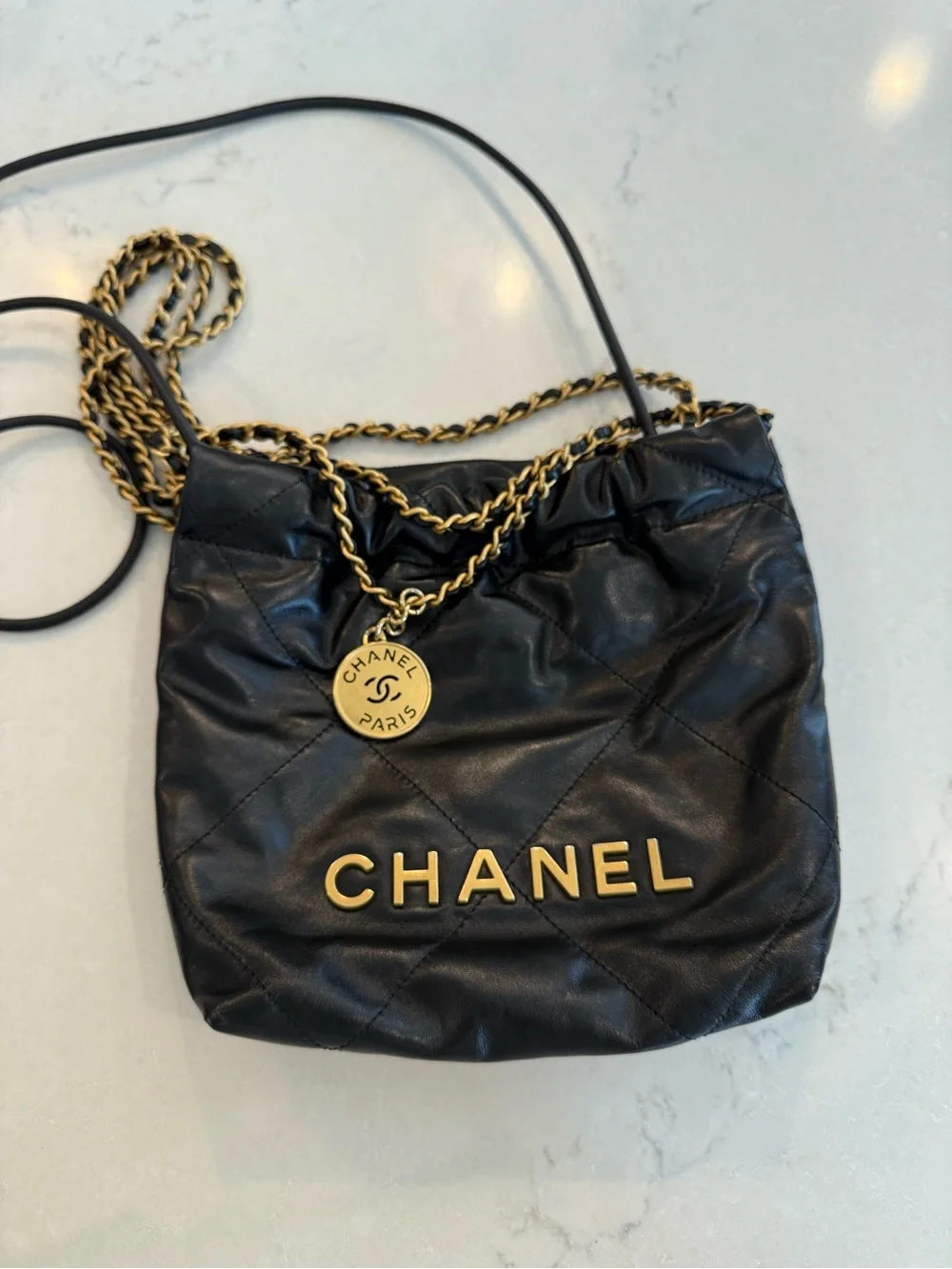 CHANEL 22 Mini Black Quilted Leather Drawstring Crossbody with Gold Logo Charm
